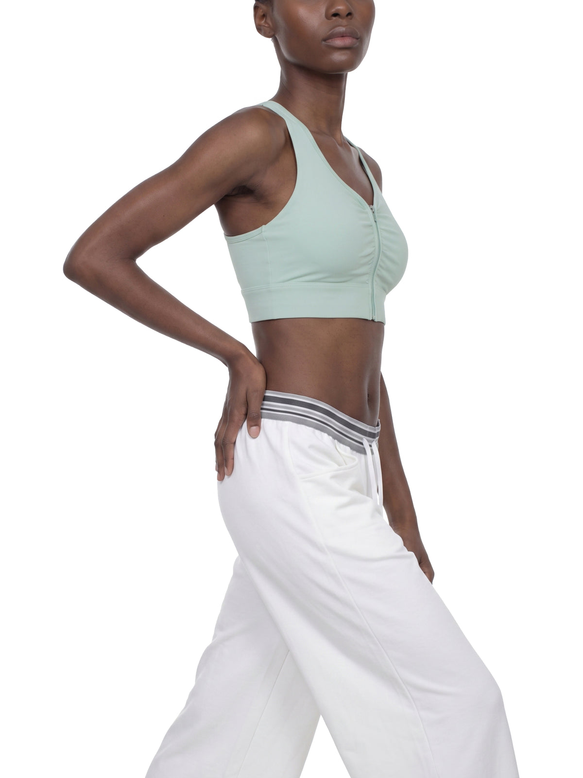 YA TOUR Women's Cropped Zip Sports Bra — on-model side view showing cropped fit and front zip closure
