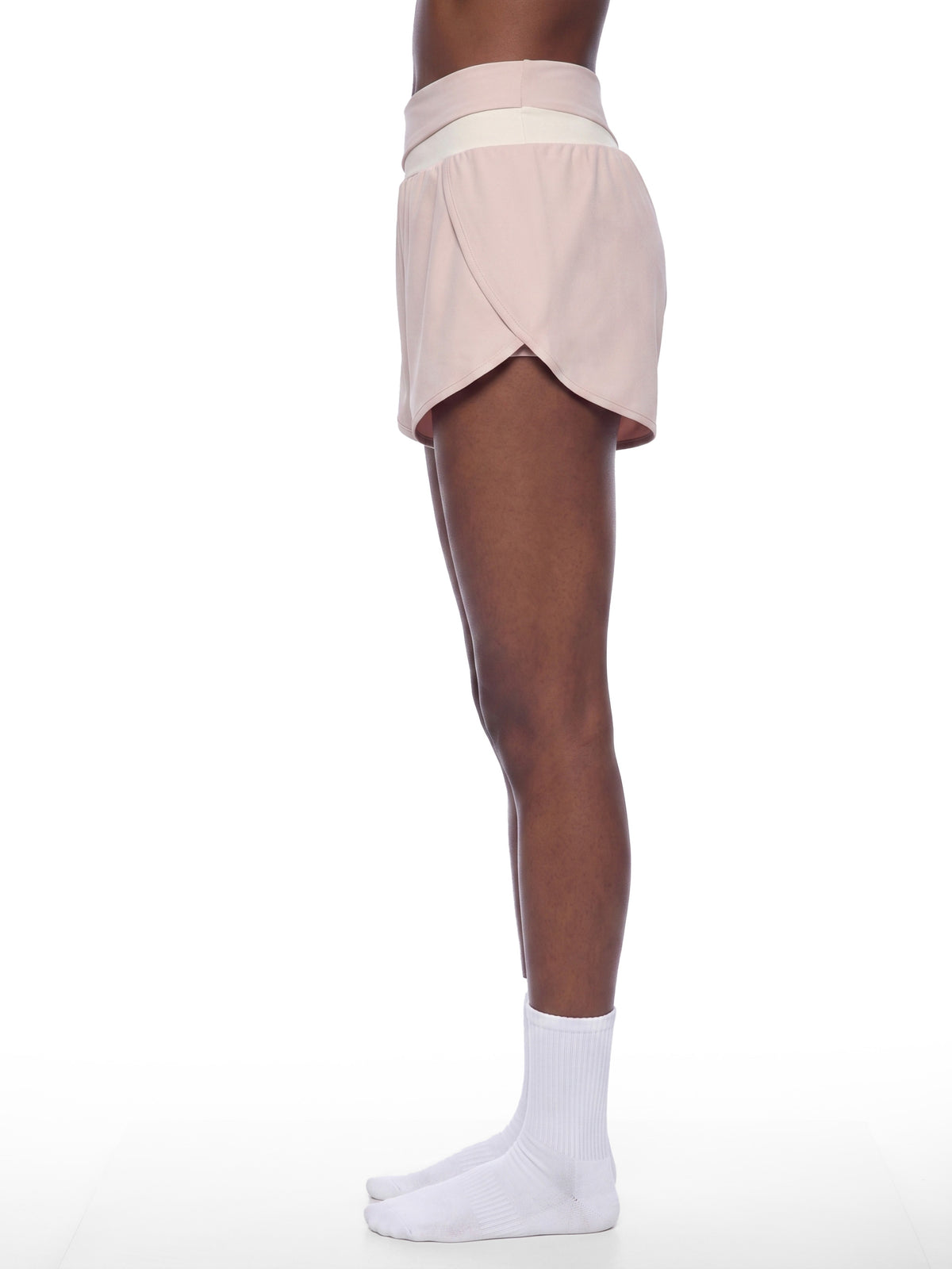YA TOUR Women's Tennis Panelled Shorts – Light Pink with Apricot, on-model side view showing crossover high-waist waistband, overlay construction and inner liner