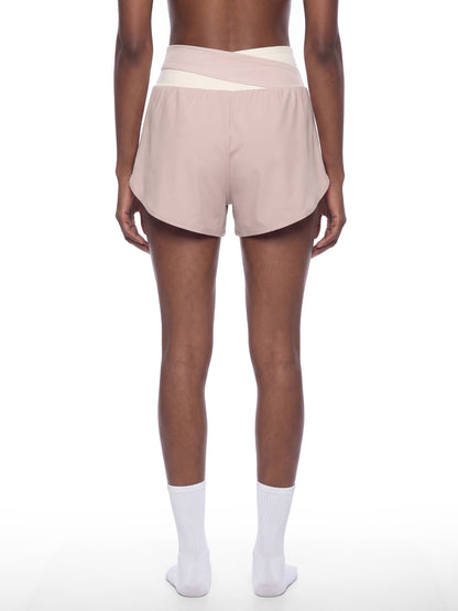 YA TOUR Women's Tennis Panelled Shorts – Light Pink with Apricot, on-model back view showing crossover waistband panel, overlay silhouette and high-waist fit